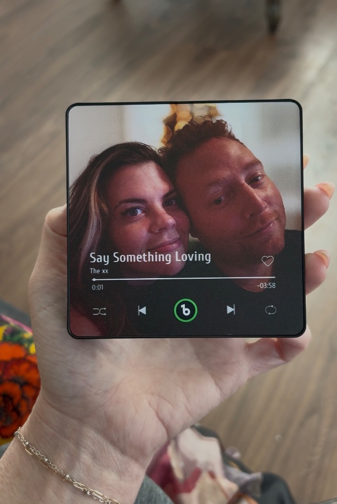 Ímã musical com foto de casal sendo segurado na mão